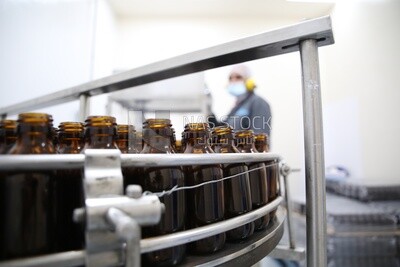 Medicine bottles stacked on the conveyor belt in a machine
