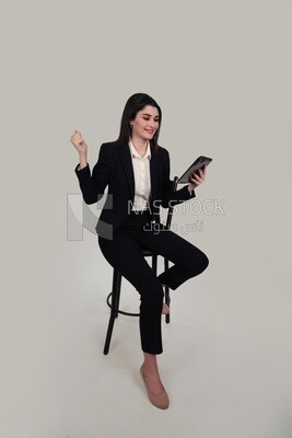 صورة لسيدة أعمال ترتدى بدلة رسمية جالسة على كرسي تحمل تابلت ، وتطوير الأعمال والشراكات ، واجتماع عمل ، موديل