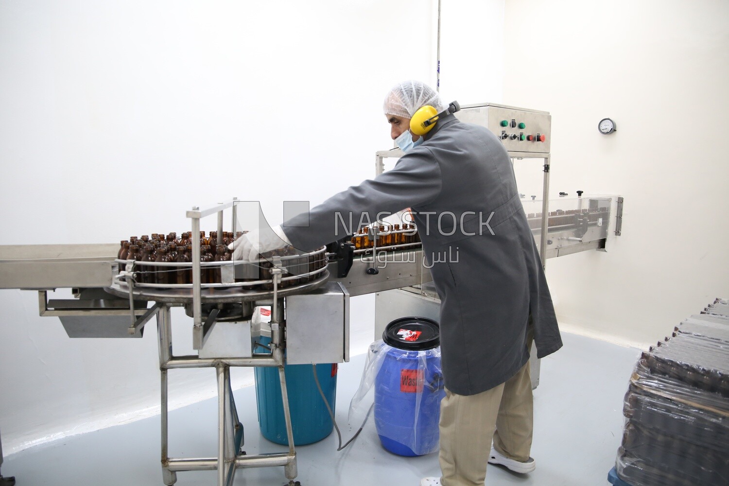 Red medicine worker placing bottles to fill medicine