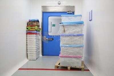 Plastic boxes in a factory corridor near the emergency door