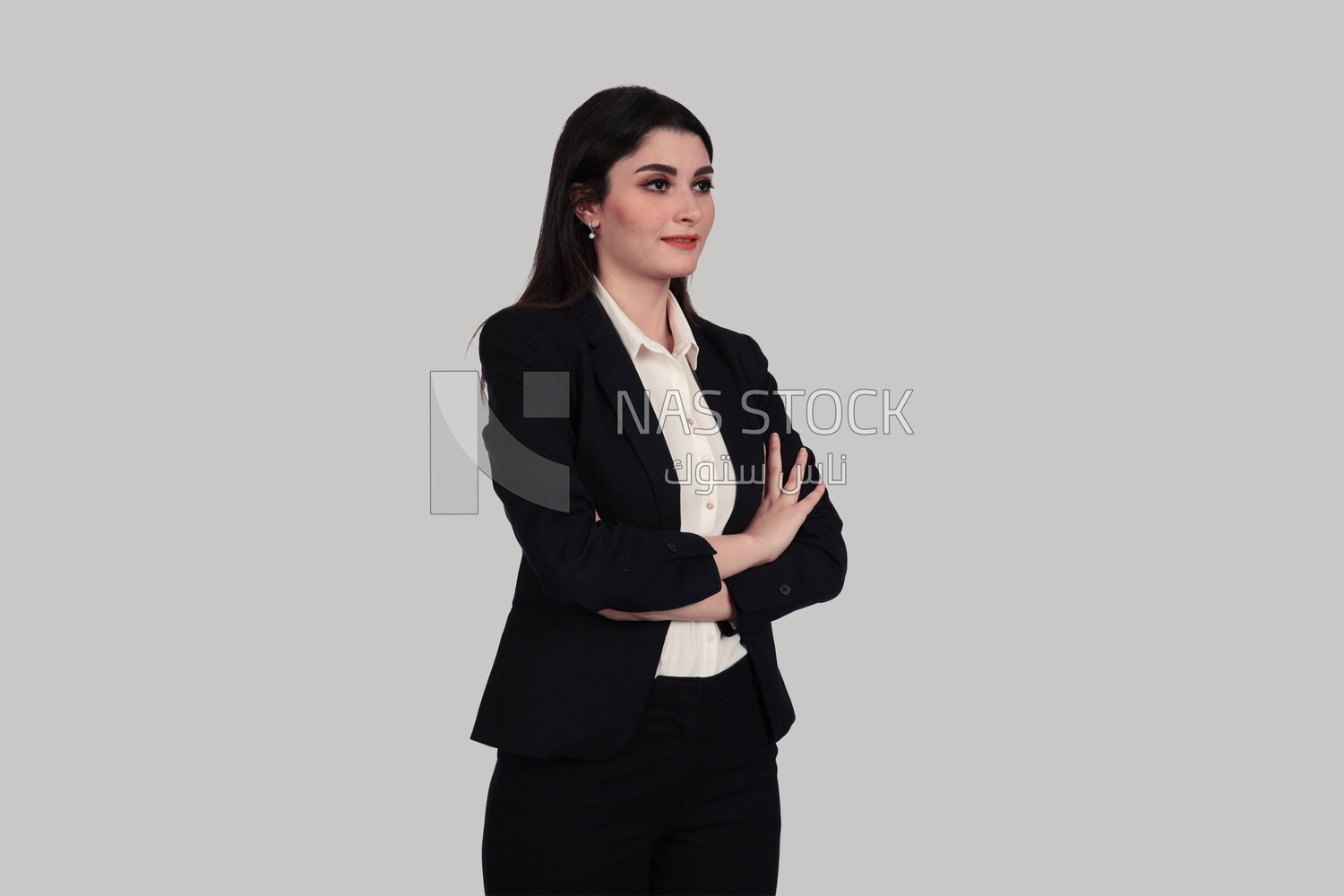 Photo of a businesswoman standing with crossed hands, meeting at the workplace, discussing work tasks, taking notes on the board