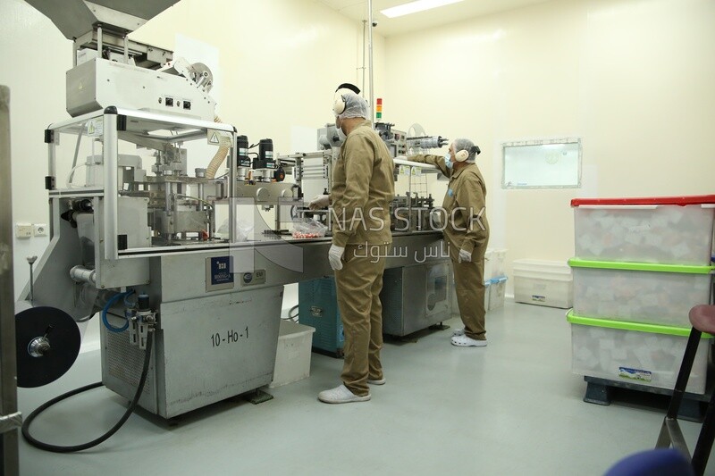 Workers in a factory start working on industrial machinery