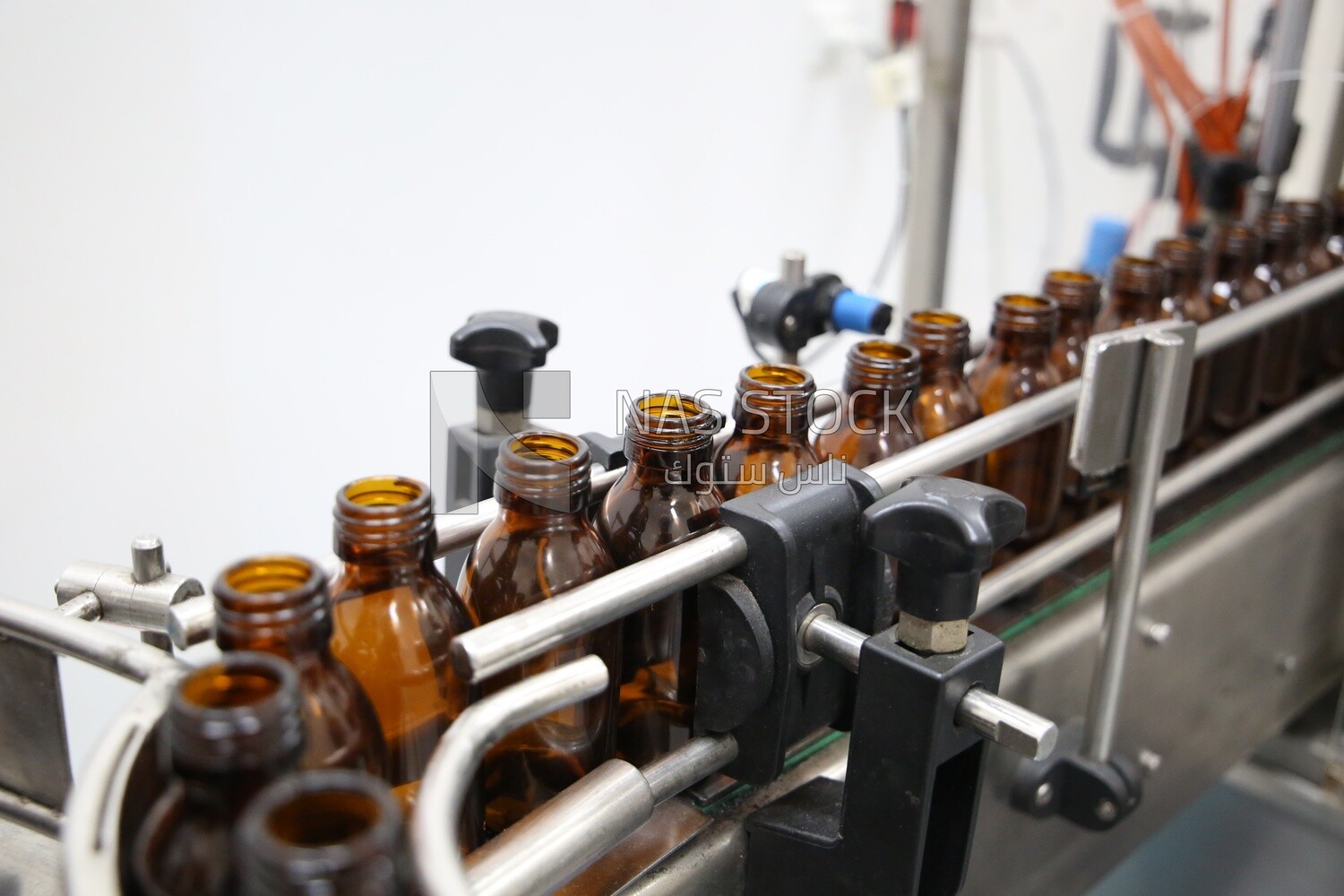 Medicine bottles stacked on the conveyor belt in a machine