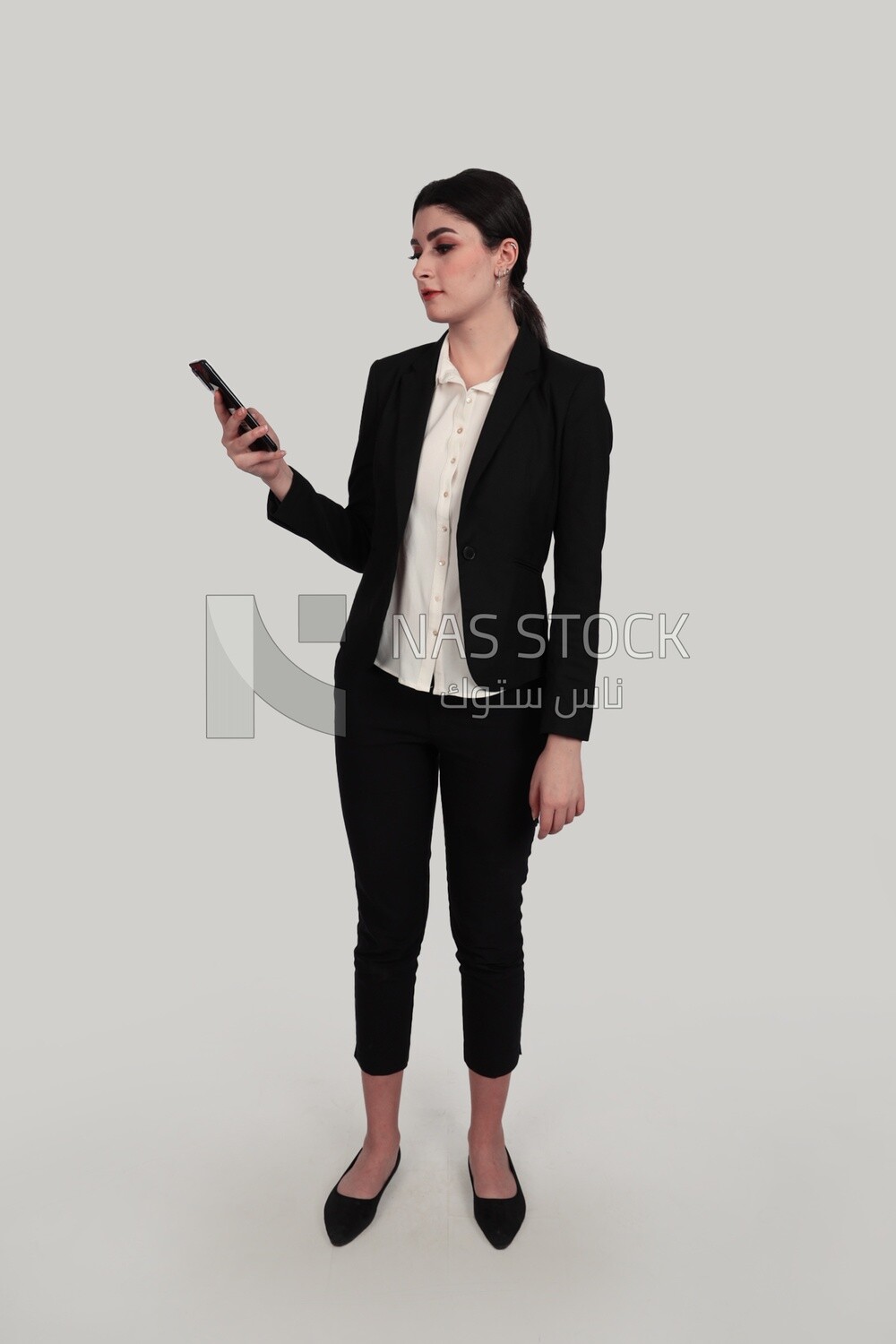 Photo of a businesswoman in formal wear standing and checking her mobile, business development and partnerships, business meeting, Model