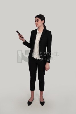 Photo of a businesswoman in formal wear standing and checking her mobile, business development and partnerships, business meeting, Model