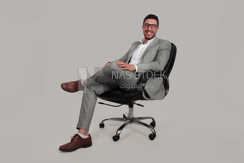 Photo of a businessman with a formal suit sitting on a chair putting a leg on a leg, business development and partnerships, business meeting, Model