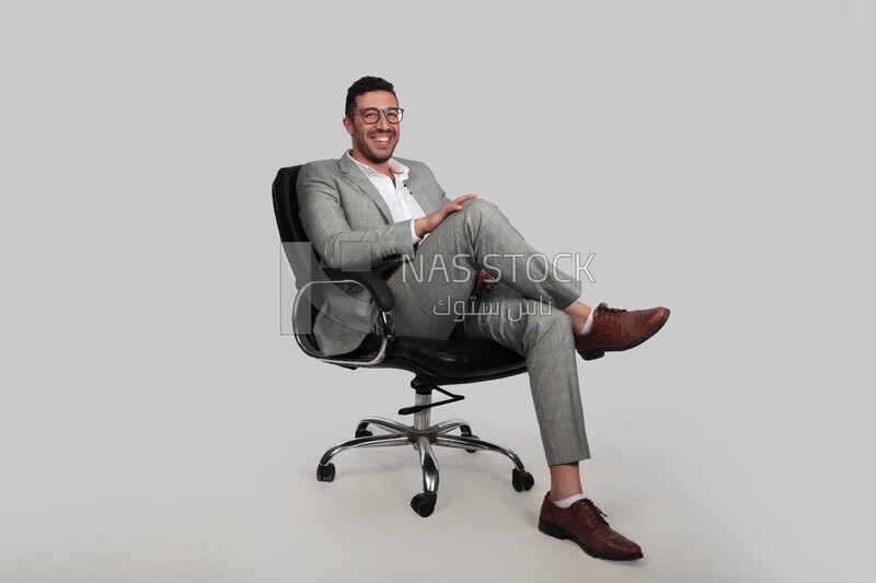 Photo of a businessman with a formal suit sitting on a chair putting a leg on a leg, business development and partnerships, business meeting, Model