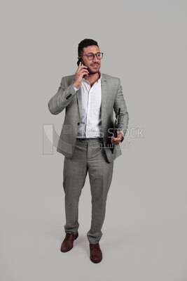 Photo of a businessman with a formal suit holding documents while talking on the phone, business development and partnerships, business meeting, Model