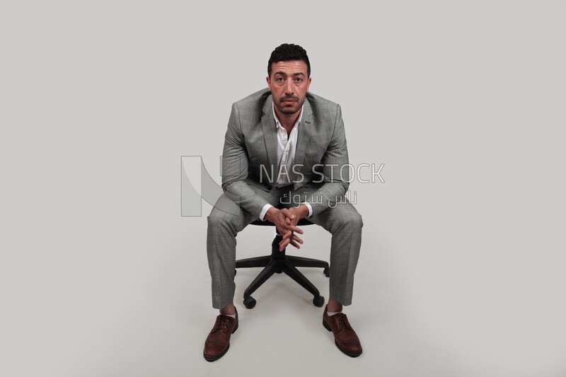 Photo of a businessman with formal wear sitting on a chair, business development and partnerships, business meeting, Model