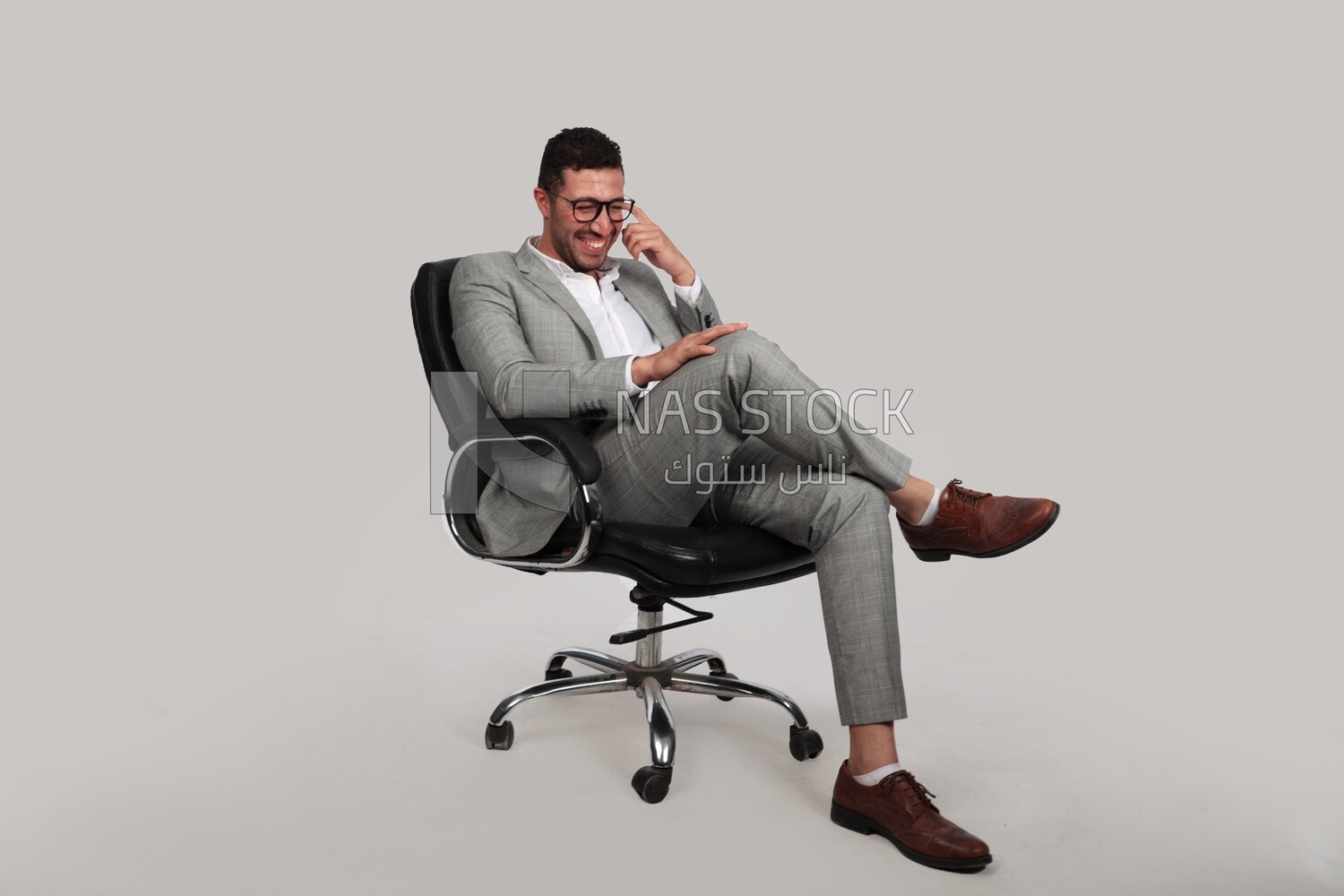 Photo of a businessman with a formal suit sitting on a chair putting a leg on a leg, business development and partnerships, business meeting, Model