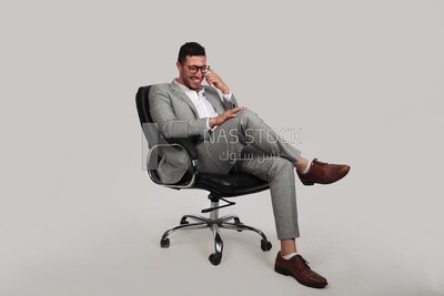 Photo of a businessman with a formal suit sitting on a chair putting a leg on a leg, business development and partnerships, business meeting, Model