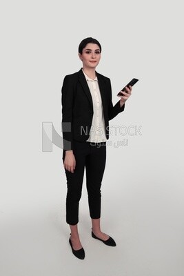 Photo of a businesswoman in formal wear standing and checking her mobile, business development and partnerships, business meeting, Model