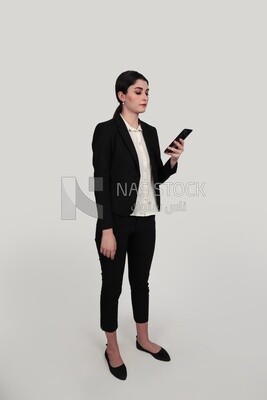 Photo of a businesswoman in formal wear standing and checking her mobile, business development and partnerships, business meeting, Model