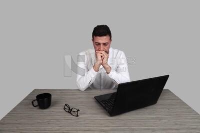 Photo of a businessman with a formal suit sitting at a desk working on a laptop thinking, business development and partnerships, business meeting, Model