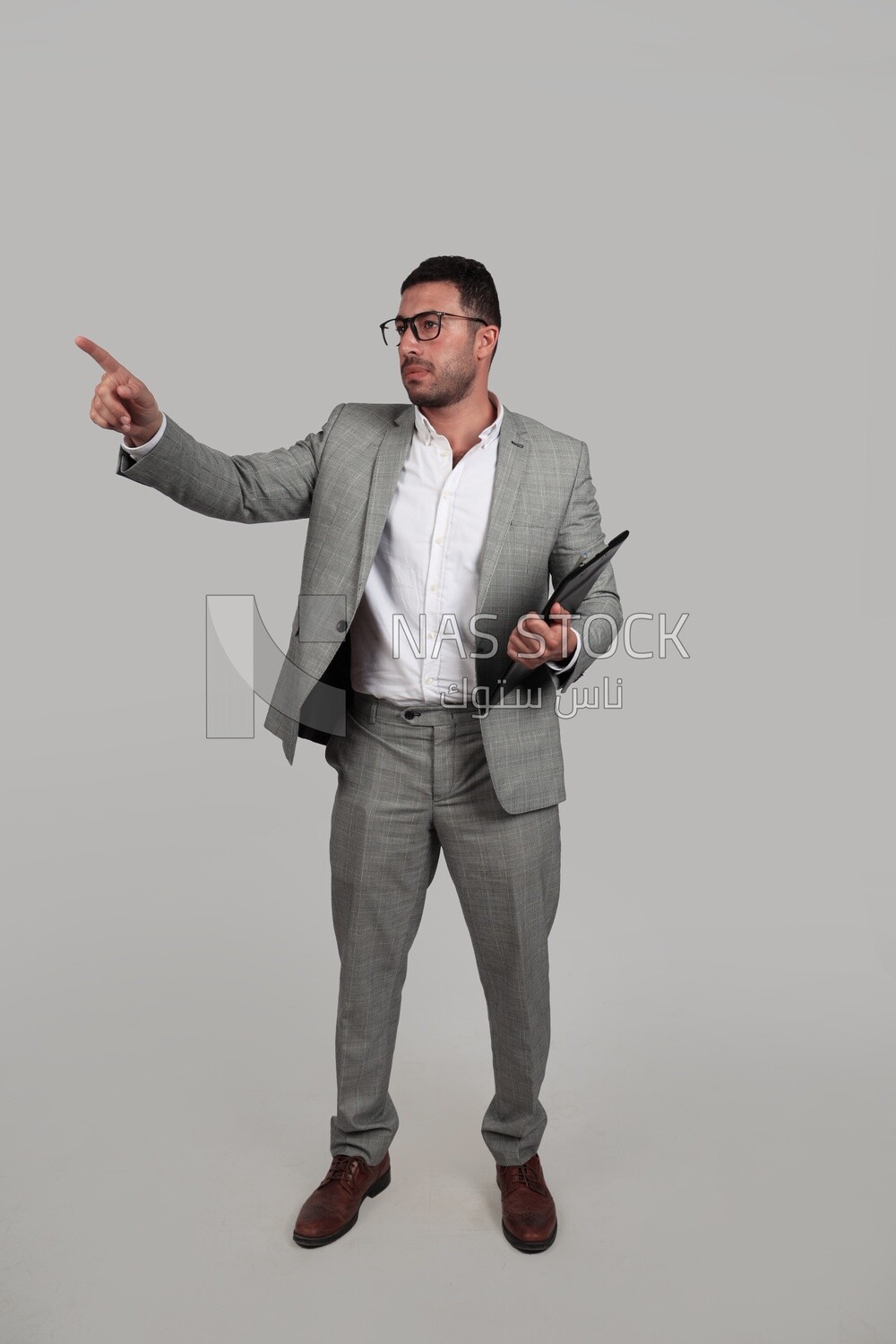 Photo of a businessman with a formal suit holding documents and pointing away, business development and partnerships, business meeting, Model