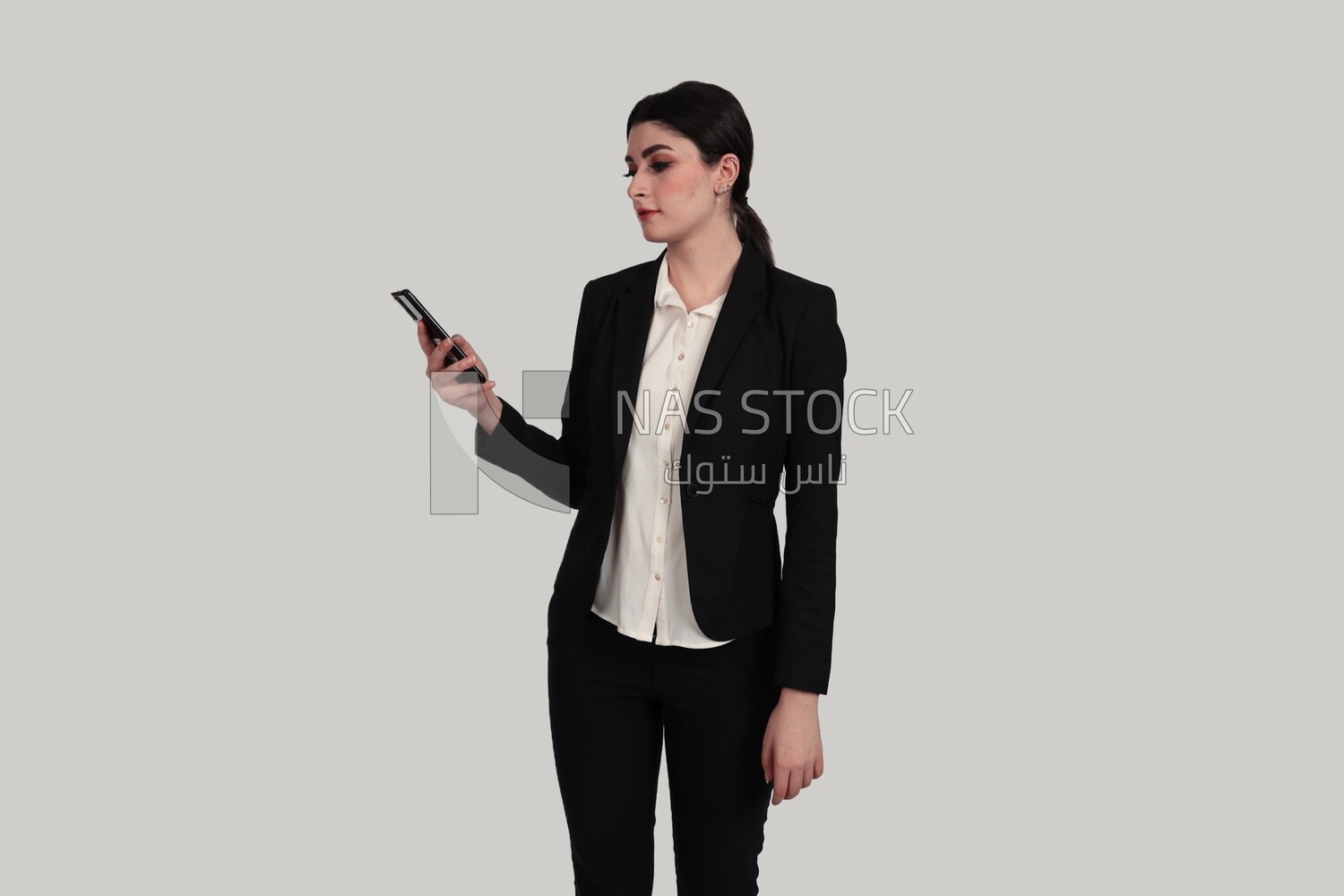 Photo of a businesswoman in formal wear standing and checking her mobile, business development and partnerships, business meeting, Model
