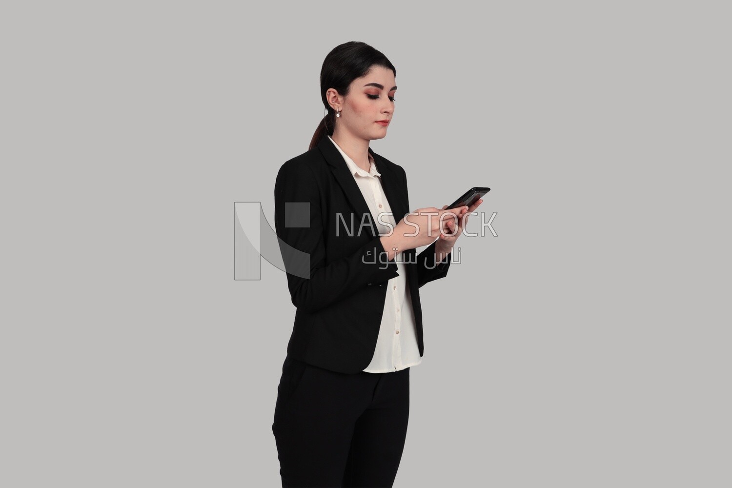 Photo of a businesswoman in formal wear standing and checking her mobile, business development and partnerships, business meeting, Model