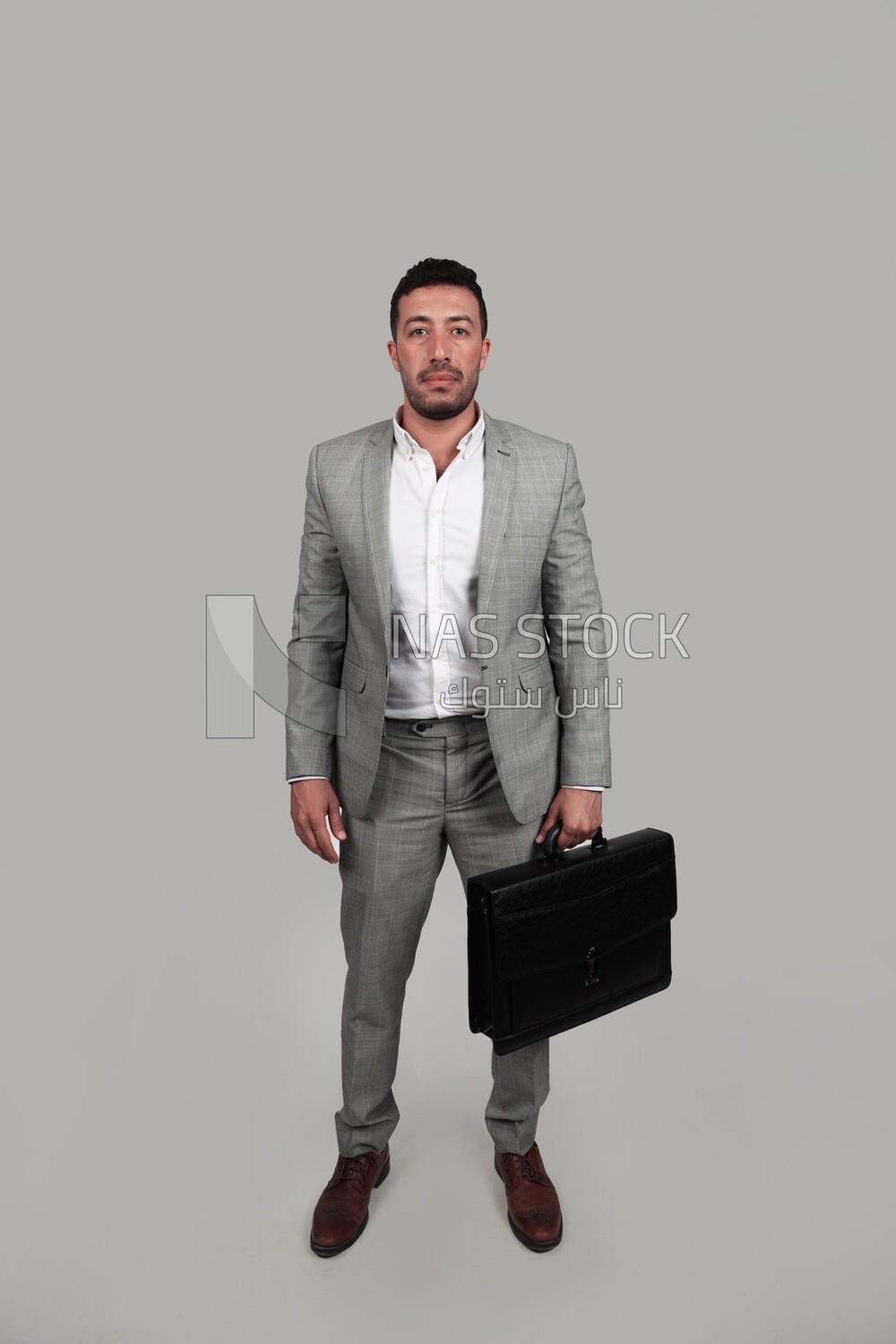 Photo of a businessman with a formal suit holding a leather bag, business development and partnerships, business meeting, Model
