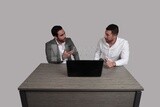 Photo of two men sitting in the office, discussing the work, business development and partnerships, business meeting, Model