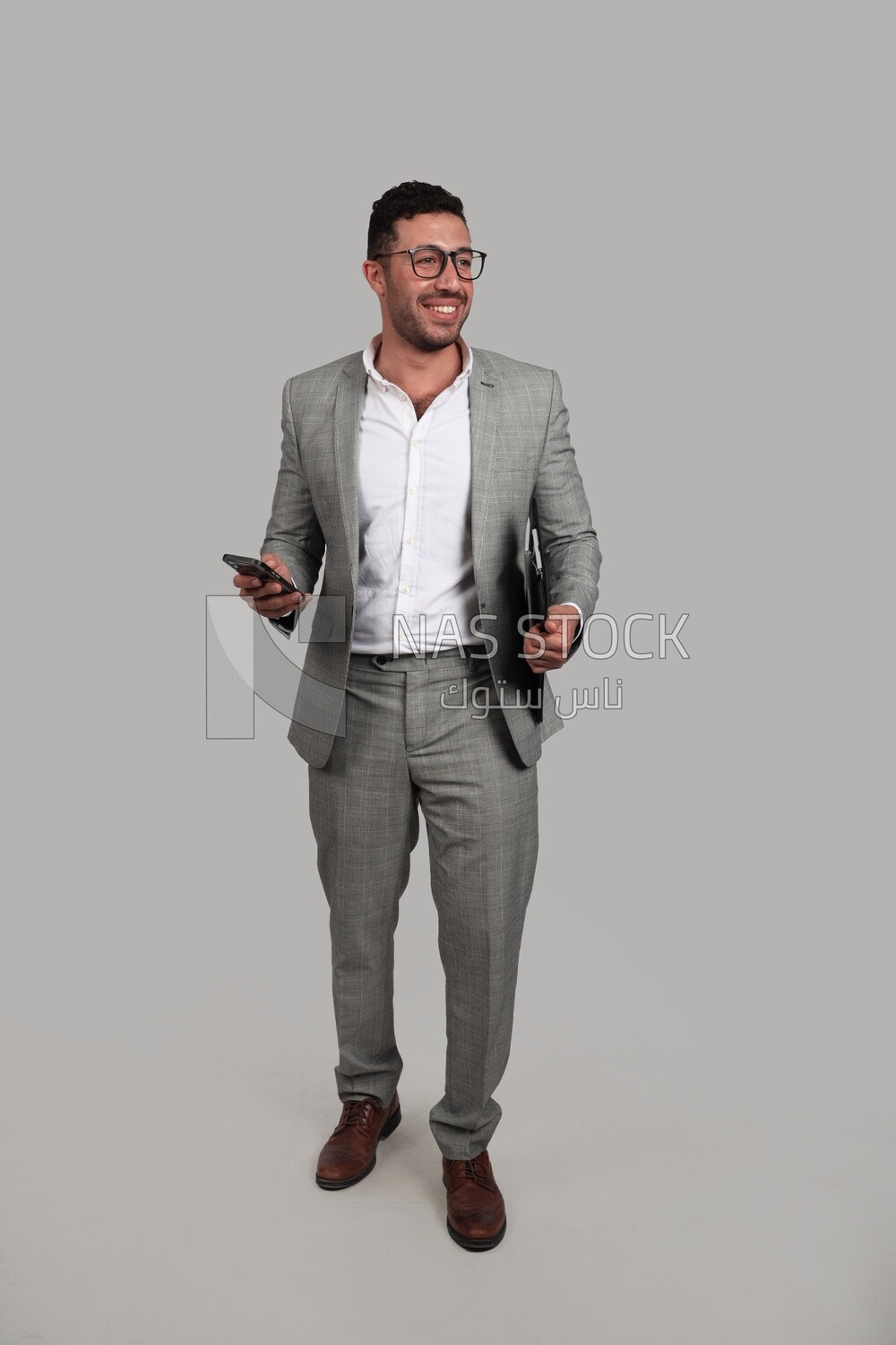 Photo of a businessman with a formal suit holding documents and checking his mobile, business development and partnerships, business meeting, Model