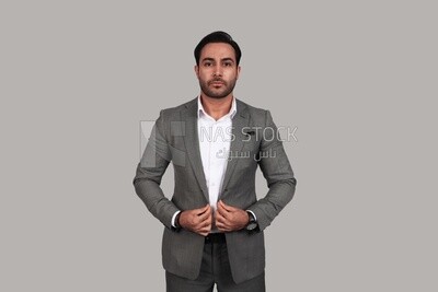 Photo of a businessman with a formal suit holding his hand on the suit button, business development and partnerships, business meeting, Model