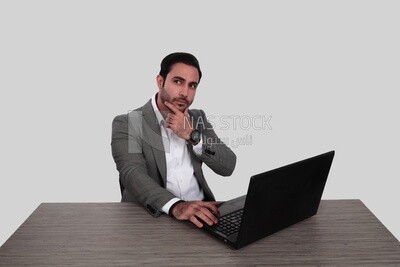 Photo of a businessman with a formal suit sitting at a desk working on a laptop, business development and partnerships, business meeting, Model