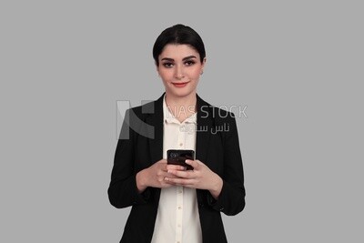 Photo of a businesswoman in formal wear standing and checking her mobile, business development and partnerships, business meeting, Model