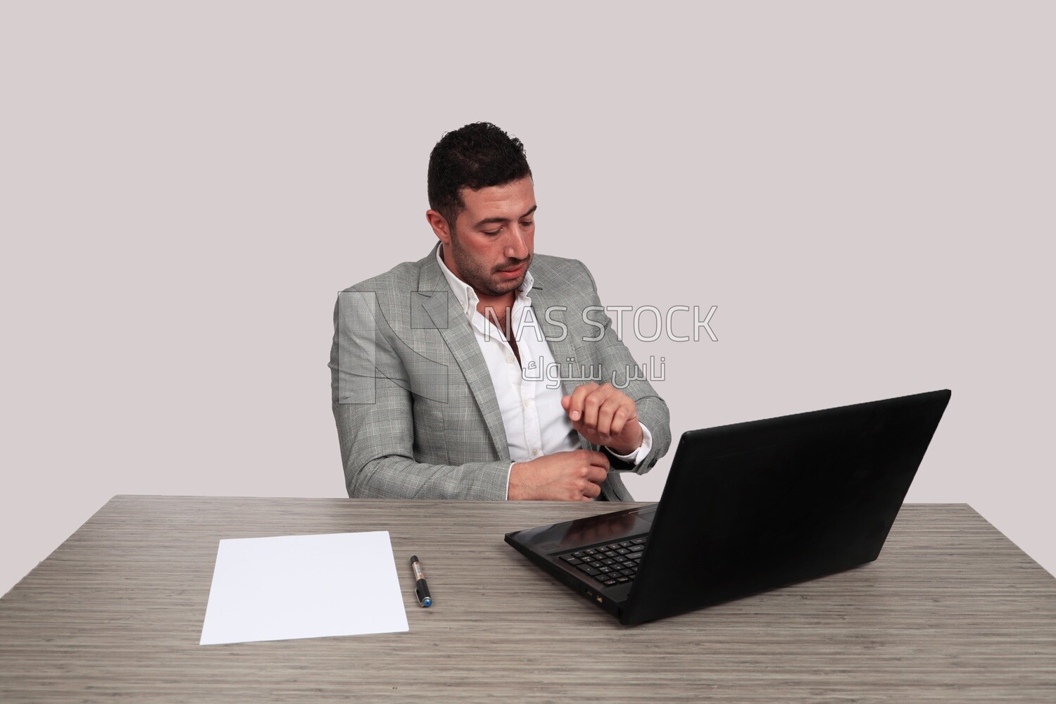 Photo of a businessman with a formal suit sitting at a desk working on a laptop, business development and partnerships, business meeting, Model