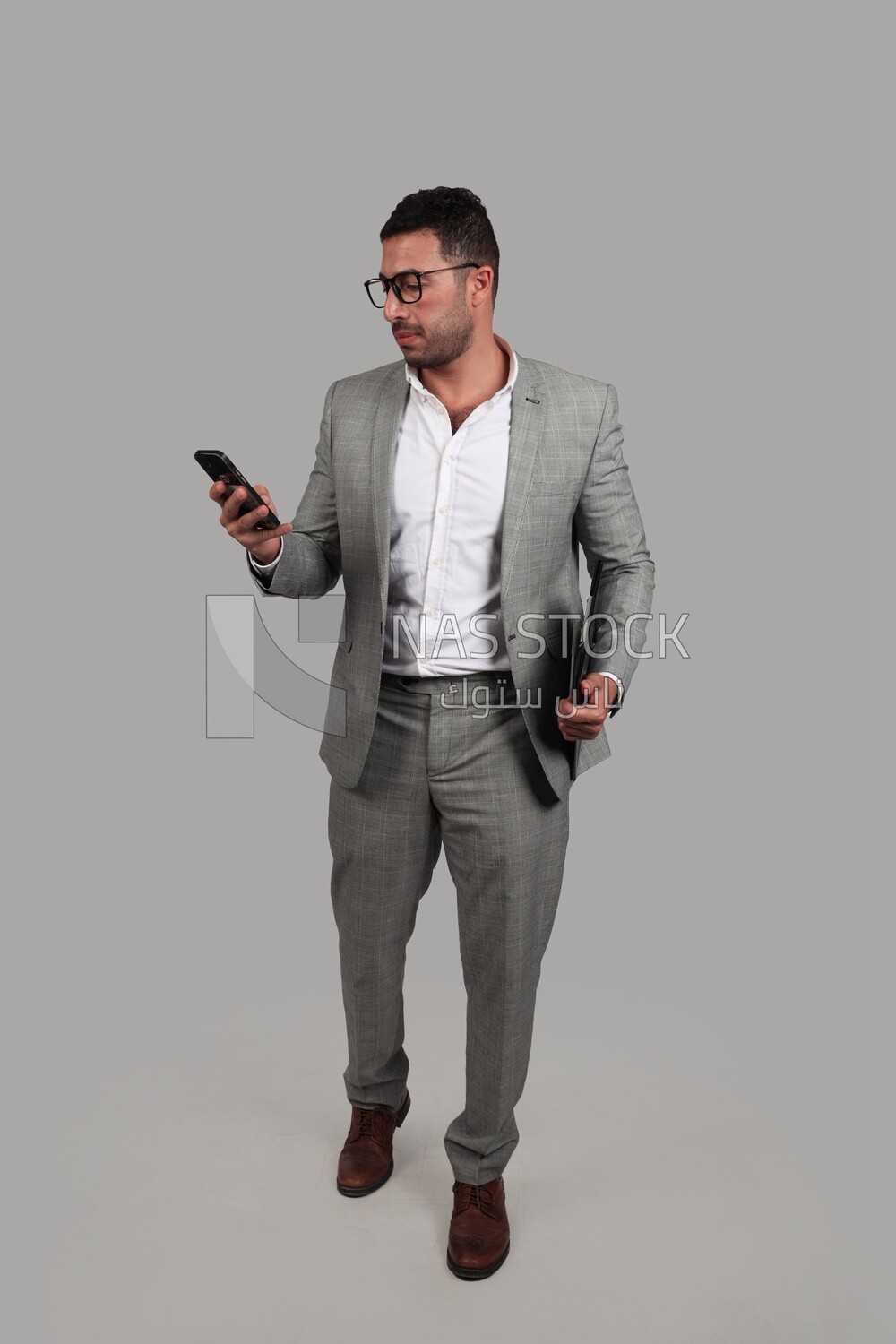 Photo of a businessman with a formal suit holding documents and checking his mobile, business development and partnerships, business meeting, Model