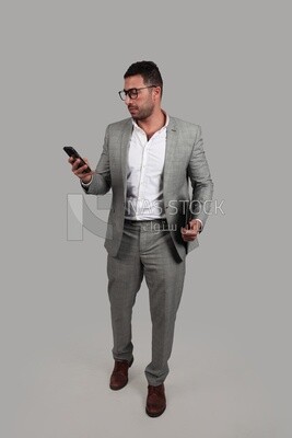Photo of a businessman with a formal suit holding documents and checking his mobile, business development and partnerships, business meeting, Model