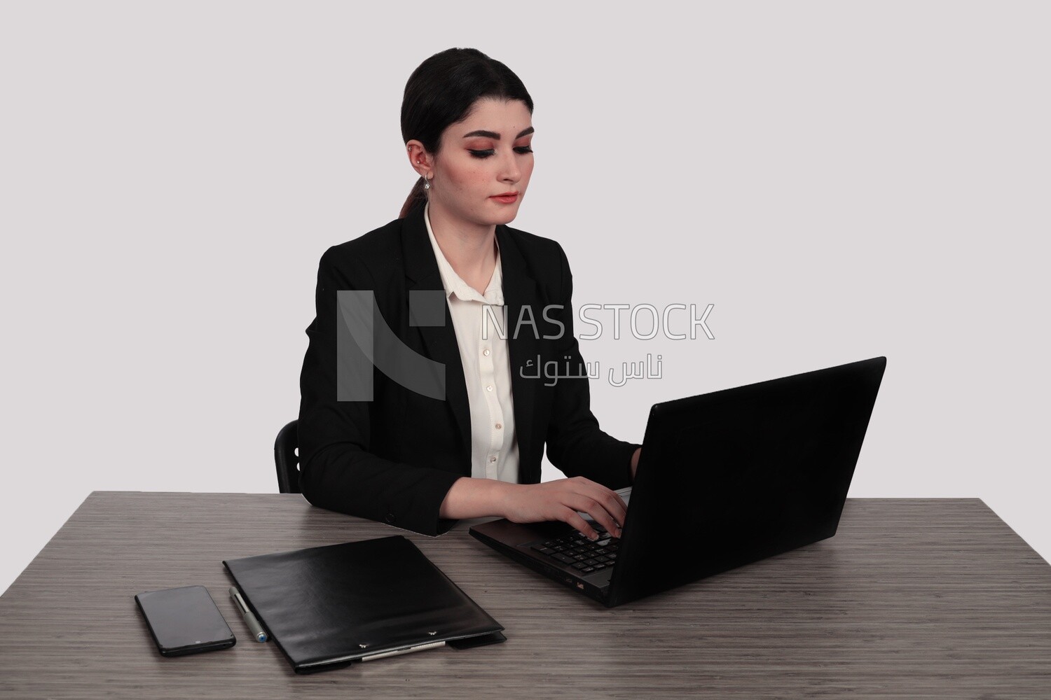 Photo of a businesswoman with a formal suit sitting at a desk working on a laptop, business development and partnerships, business meeting, Model