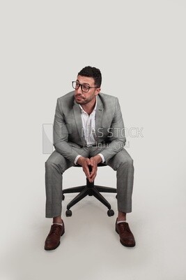 Photo of a businessman with formal wear sitting on a chair, business development and partnerships, business meeting, Model