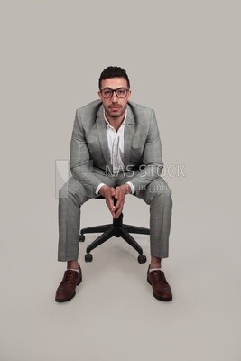 Photo of a businessman with formal wear sitting on a chair, business development and partnerships, business meeting, Model