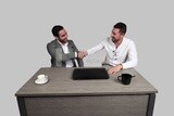 Photo of two businessmen sitting in the office and shaking hands, business development and partnerships, business meeting, Model