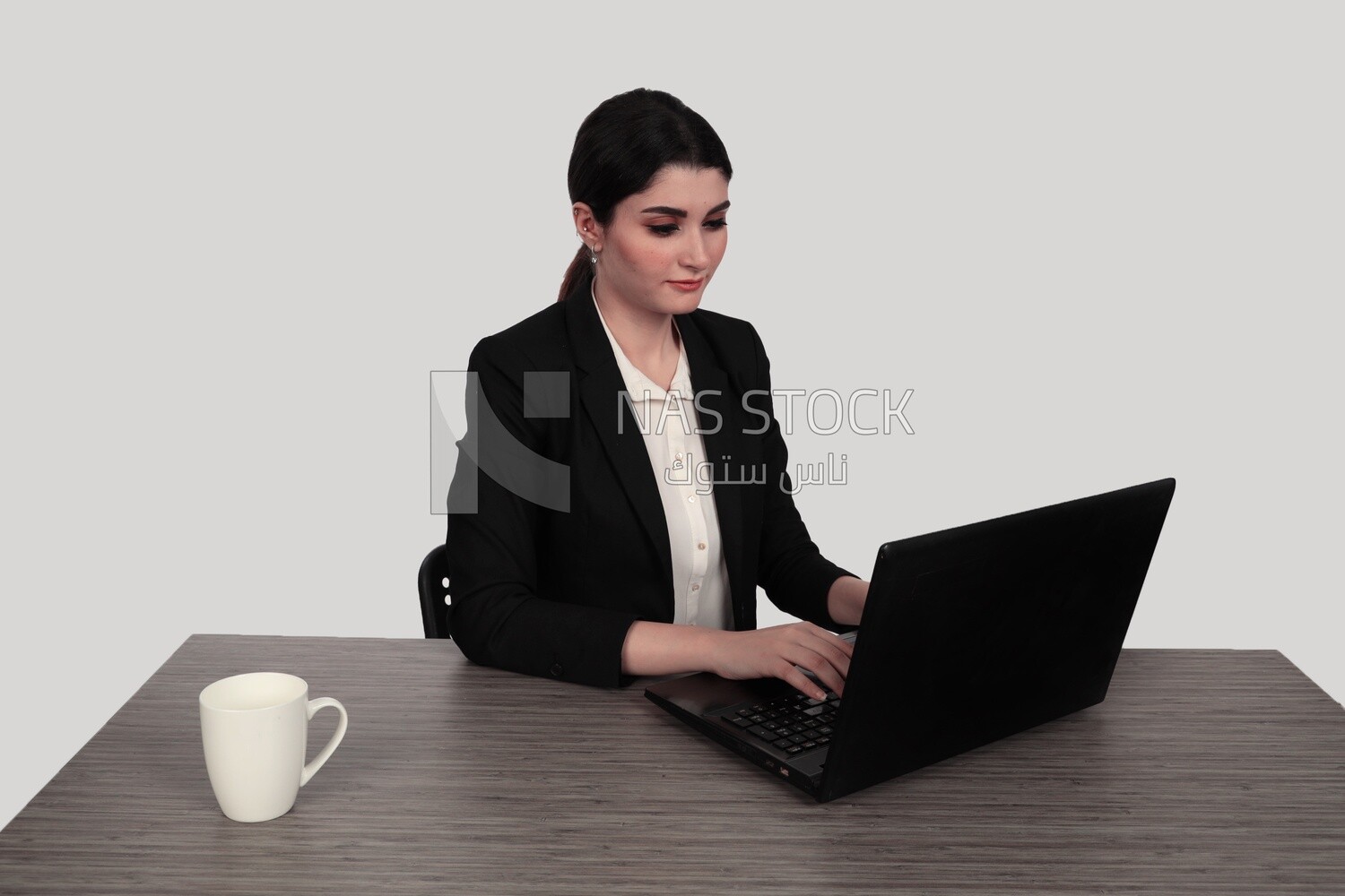 Photo of a businesswoman with a formal suit sitting at a desk working on a laptop, business development and partnerships, business meeting, Model