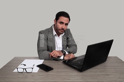 صورة لرجل أعمال يرتدي بدلة رسمية جالسًا على مكتب يعمل على كمبيوتر محمول ، وتطوير الأعمال والشراكات ، واجتماع عمل ، موديل