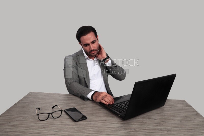 Photo of a businessman with a formal suit sitting at a desk working on a laptop, business development and partnerships, business meeting, Model