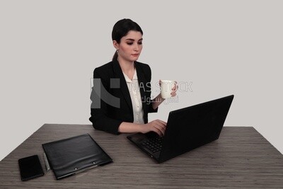 Photo of a businesswoman with a formal suit sitting at a desk drinking coffee while she works on a laptop, business development and partnerships, business meeting, Model