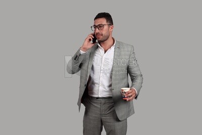 Photo of a businessman with formal wear holding a cup of tea while talking on the phone, business development and partnerships, business meeting, Model