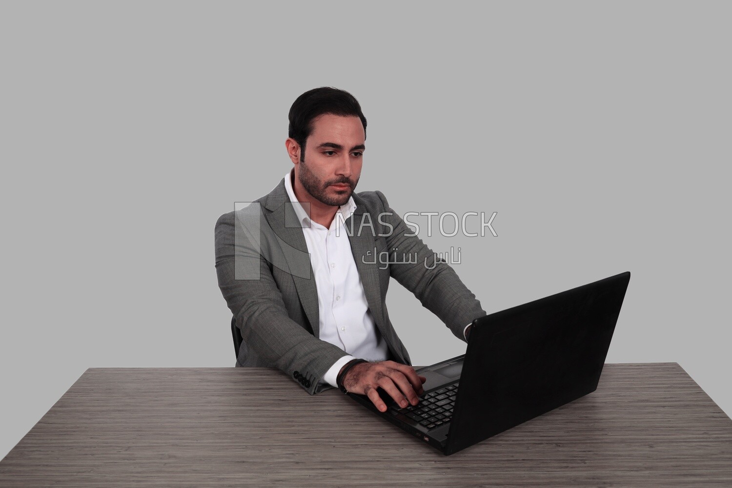 Photo of a businessman with a formal suit sitting at a desk working on a laptop, business development and partnerships, business meeting, Model