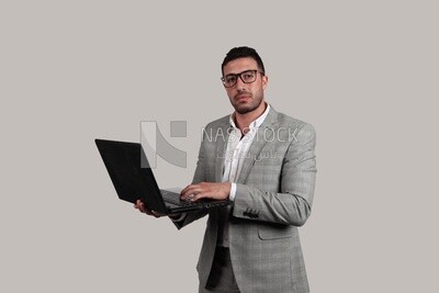 Photo of a businessman with a formal suit holding a laptop, business development and partnerships, business meeting, Model