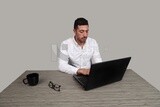 Photo of a businessman with a formal suit sitting at a desk working on a laptop, business development and partnerships, business meeting, Model