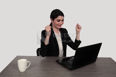 Photo of a businessman with a formal suit sitting at a desk working on a laptop looking happy, business development and partnerships, business meeting, Model