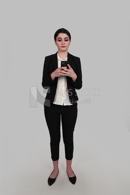 Photo of a businesswoman in formal wear standing and checking her mobile, business development and partnerships, business meeting, Model