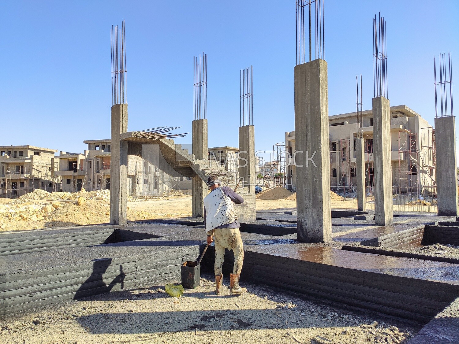 Worker coating the concrete with an anti-rust material to protect the buildings