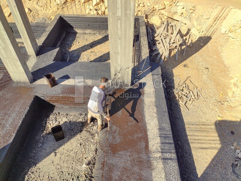 Worker coating the concrete with an anti-rust material to protect the buildings