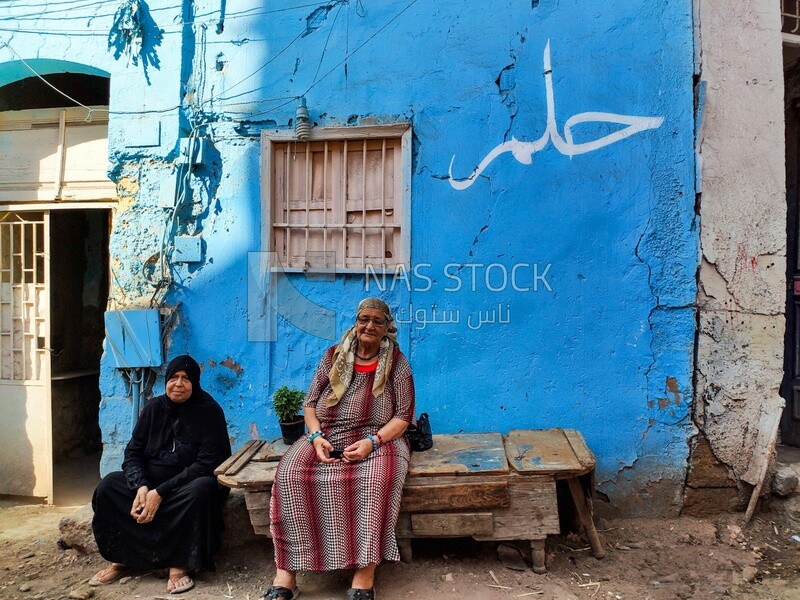Two Egyptian women sitting in front of the house in one of Cairo's neighborhoods