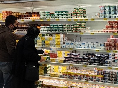 زوجة و زوج امام تلاجات حفظ منتجات الالبان من قسم الامشروبات و الاغذية