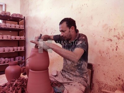 Craftsman forming pottery pots inside a pottery workshop in Egypt