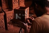 Craftsman forms a piece of pottery in the shape of a box